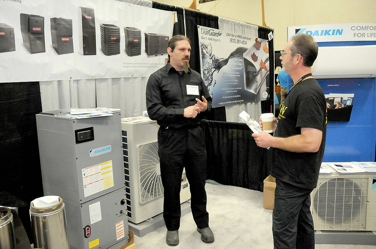 John Graham of Sequim, right, talks with Richard Fife, owner of Port Angeles-based Strait Comfort Systems, at the 38th annual KONP Home Show on Saturday at Port Angeles High School. The event featured dozens of exhibitors and displays centered on homes, home improvement and lifestyles. (Keith Thorpe/Peninsula Daily News)