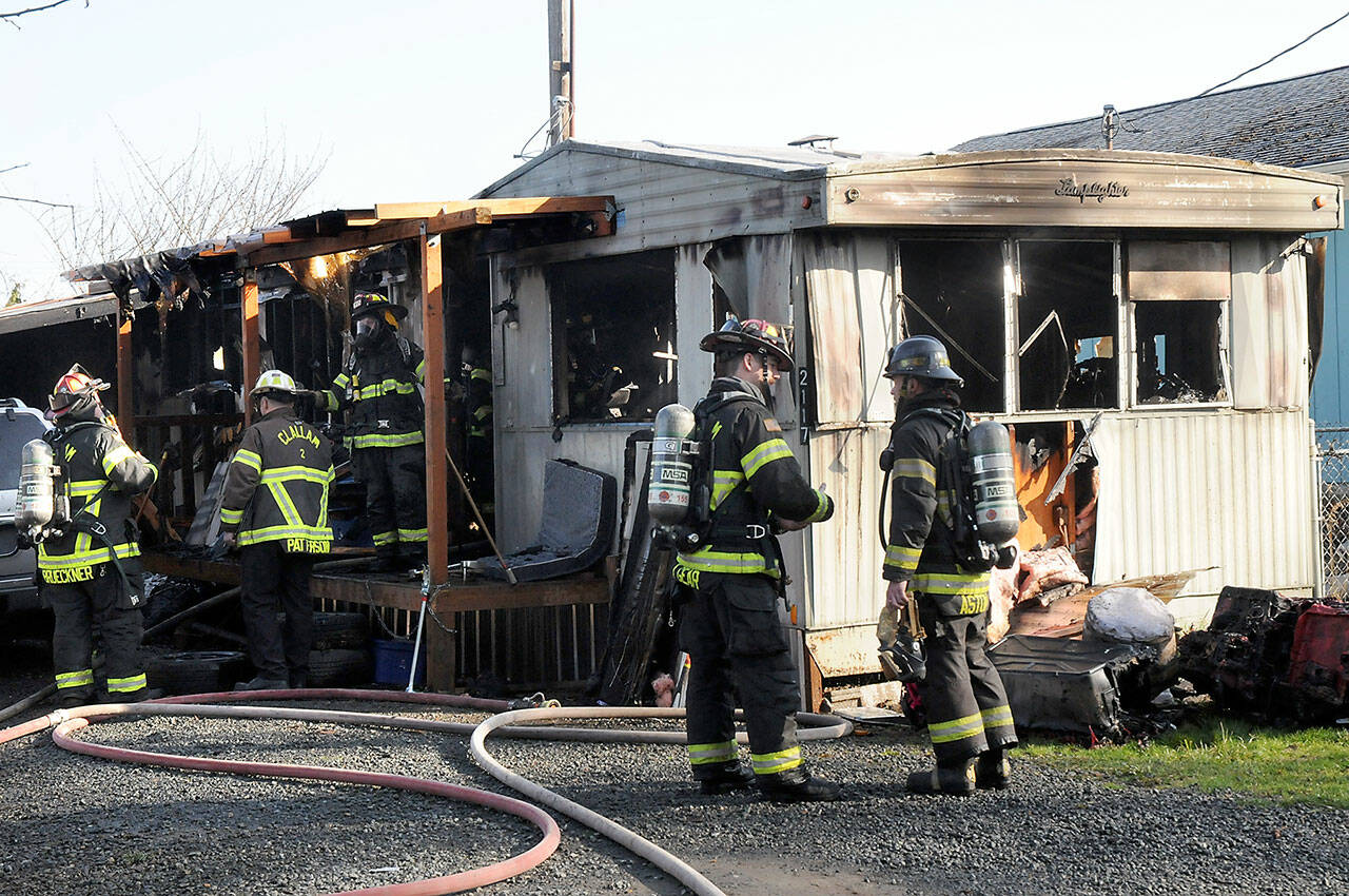 Clallam County District 2 firefighters work at the scene of a fire that destroyed a mobile home on East Fifth Avenue in Gales Addition east of Port Angeles on Saturday. (Keith Thorpe/Peninsula Daily News)