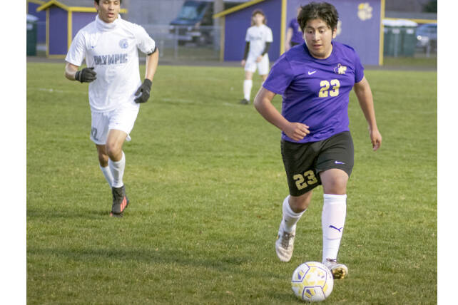 Sequim’s Adrian Mendez dribbles the ball against Olympic on Tuesday night in Sequim. (Emily Matthiessen/Olympic Peninsula News Group)
