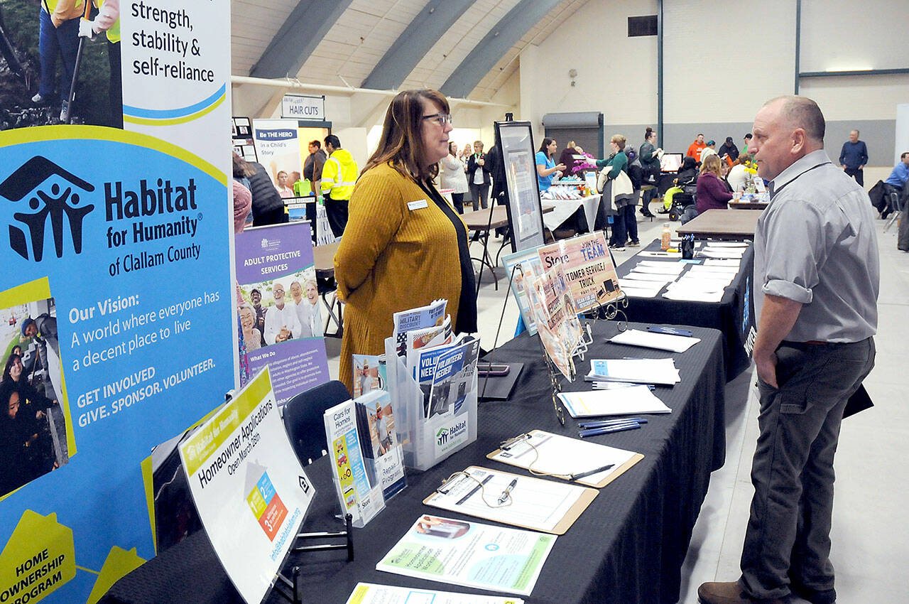 Brett Raemer of Port Angeles, right, speaks with Colleen Robinson, chief executive officer of Habitat for Humanity of Clallam County during Wednesday’s Clallam County Job Fair at Vern Burton Community Center in Port Angeles. (KEITH THORPE/PENINSULA DAILY NEWS)