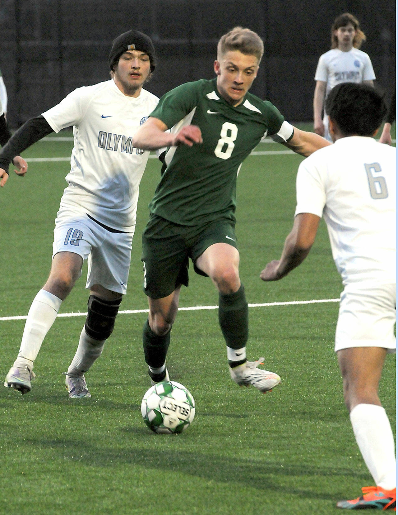 KEITH THORPE/PENINSULA DAILY NEWS Port Angeles’ Jacob Miller, center, works his way pas Olympic’s Gavin Christensen, left, and Chace Guerrero on Thursday night in Port Angeles