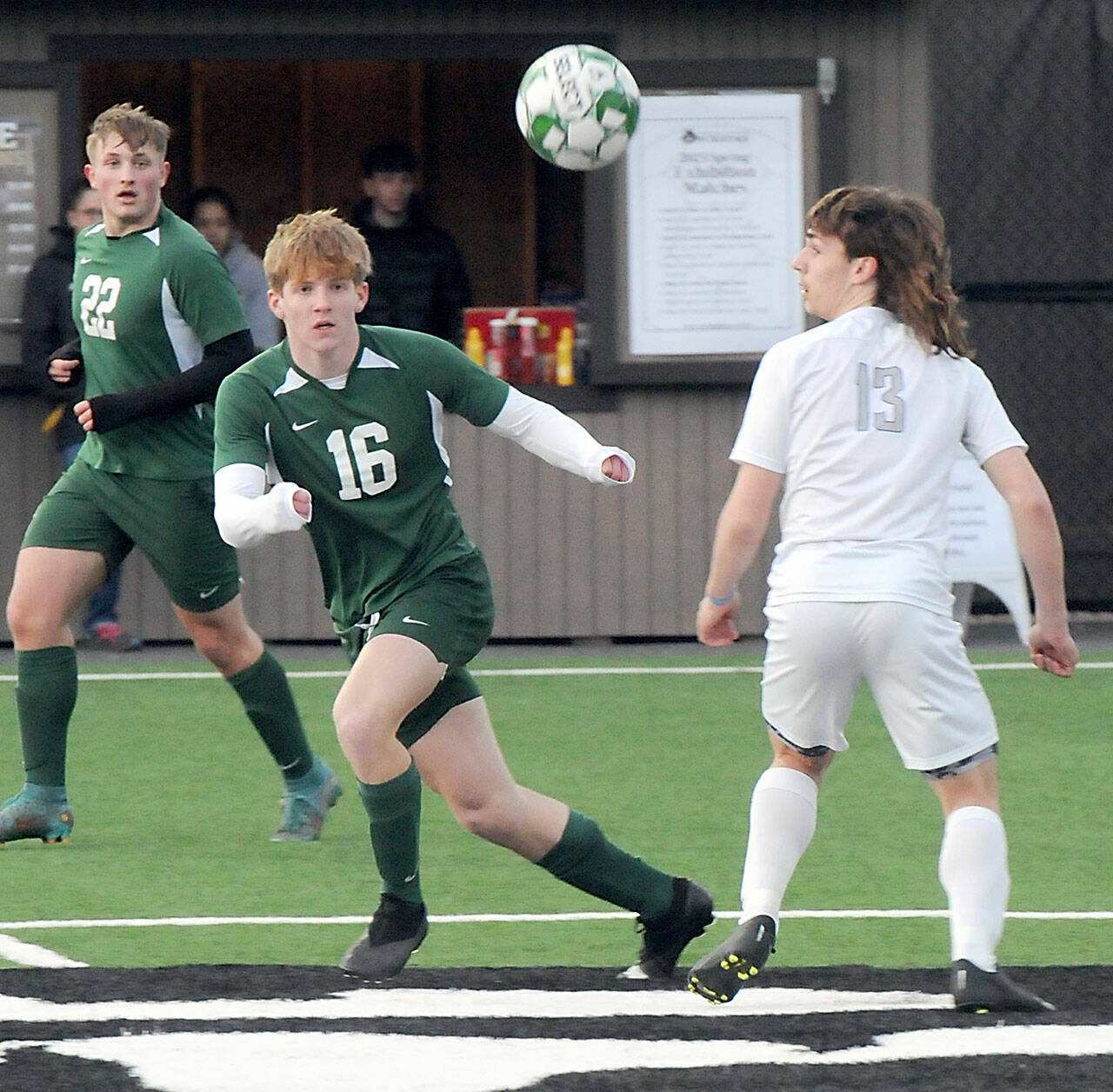 KEITH THORPE/PENINSULA DAILY NEWS Port Angeles’ Zak Alton, center, keeps track of the ball as teammate Eli Fischer, left, and Olympic’s Justin Thorsen look on during Thursday’s match at Peninsula College in Port Angeles.