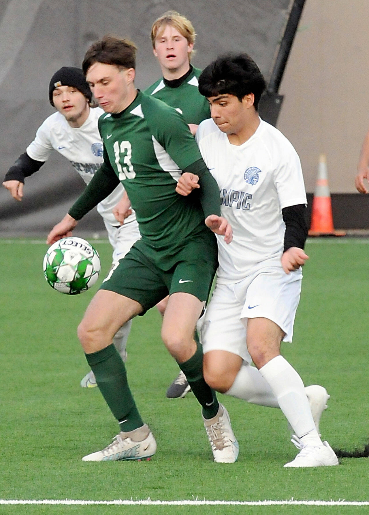 KEITH THORPE/PENINSULA DAILY NEWS Port Angeles’ Caden White, center, slips past Olympic’s Andres Manriquez, right, as Olympic midfielders Gavin Christensen, rear left, and Port Angeles’ Hannes Spieker keep watch on Thursday at Peninsula College.