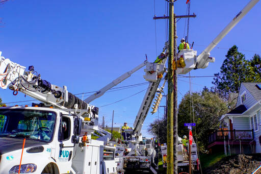 A crew from Jefferson County Public Utility District works to replace an old pole with a new one on the corner of Scott and Lawrence streets on Monday in Port Townsend. (Steve Mullensky/for Peninsula Daily News)