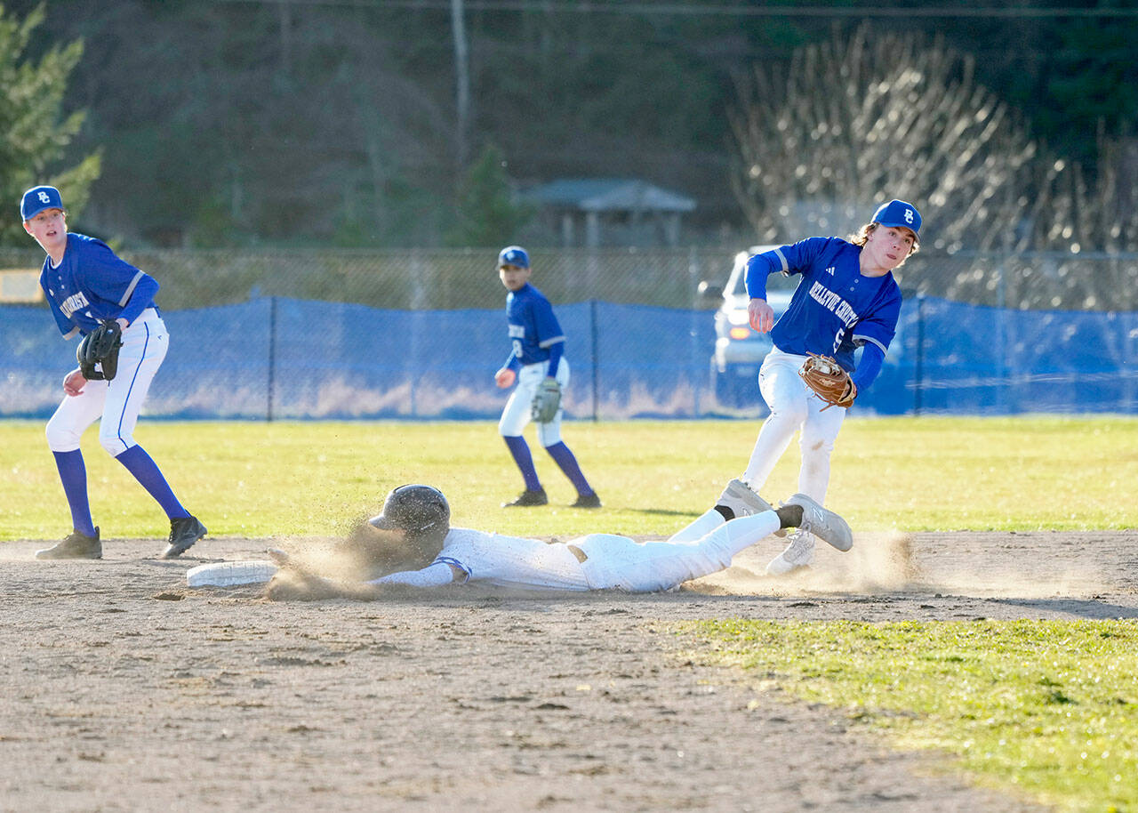 East Jefferson Rival Cash Holmes gets a face full of dirt as he beats the throw to Bellevue Christian Vikings third baseman Oeclan Englund during a Monday game played in Chimacum. (Steve Mullensky/for Peninsula Daily News)