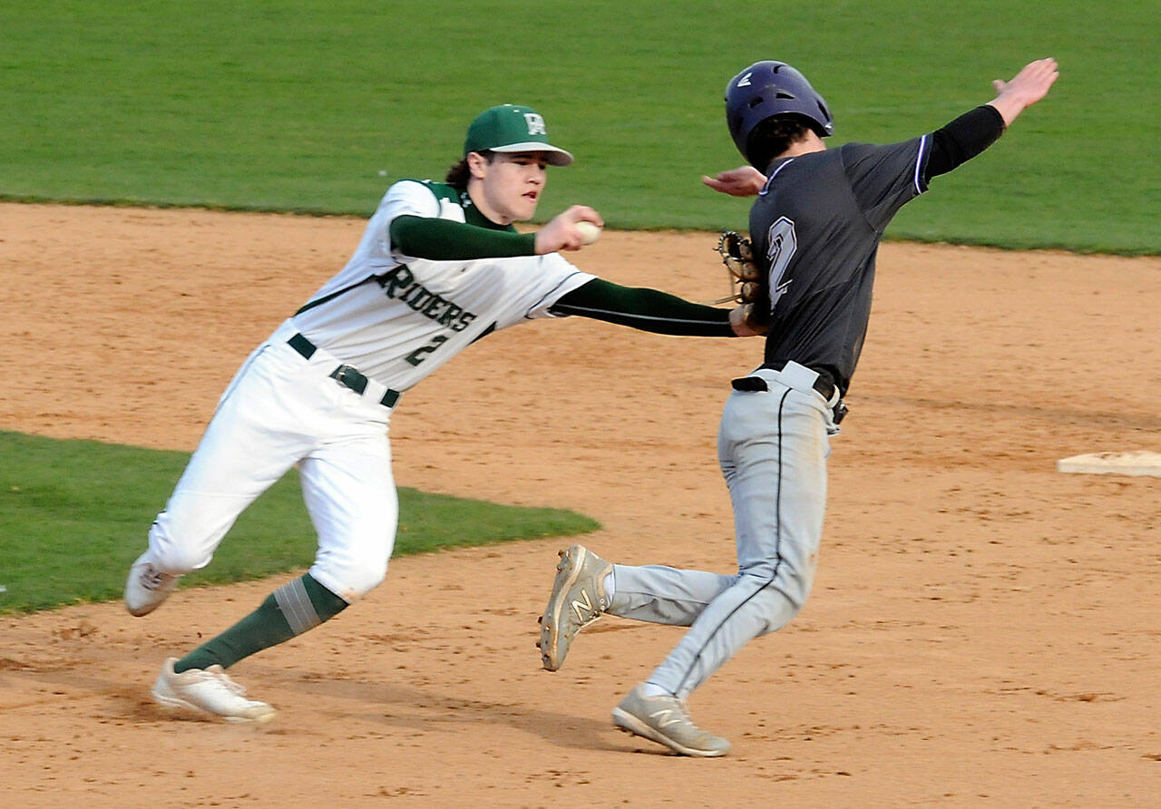 KEITH THORPE/PENINSULA DAILY NEWS Port Angeles shortstop Alex Angevine, left, tries to tag North Kitsap’s Alex Elton in a rundown between first and second during the third inning on Tuesday at Port Angeles Civic Field.