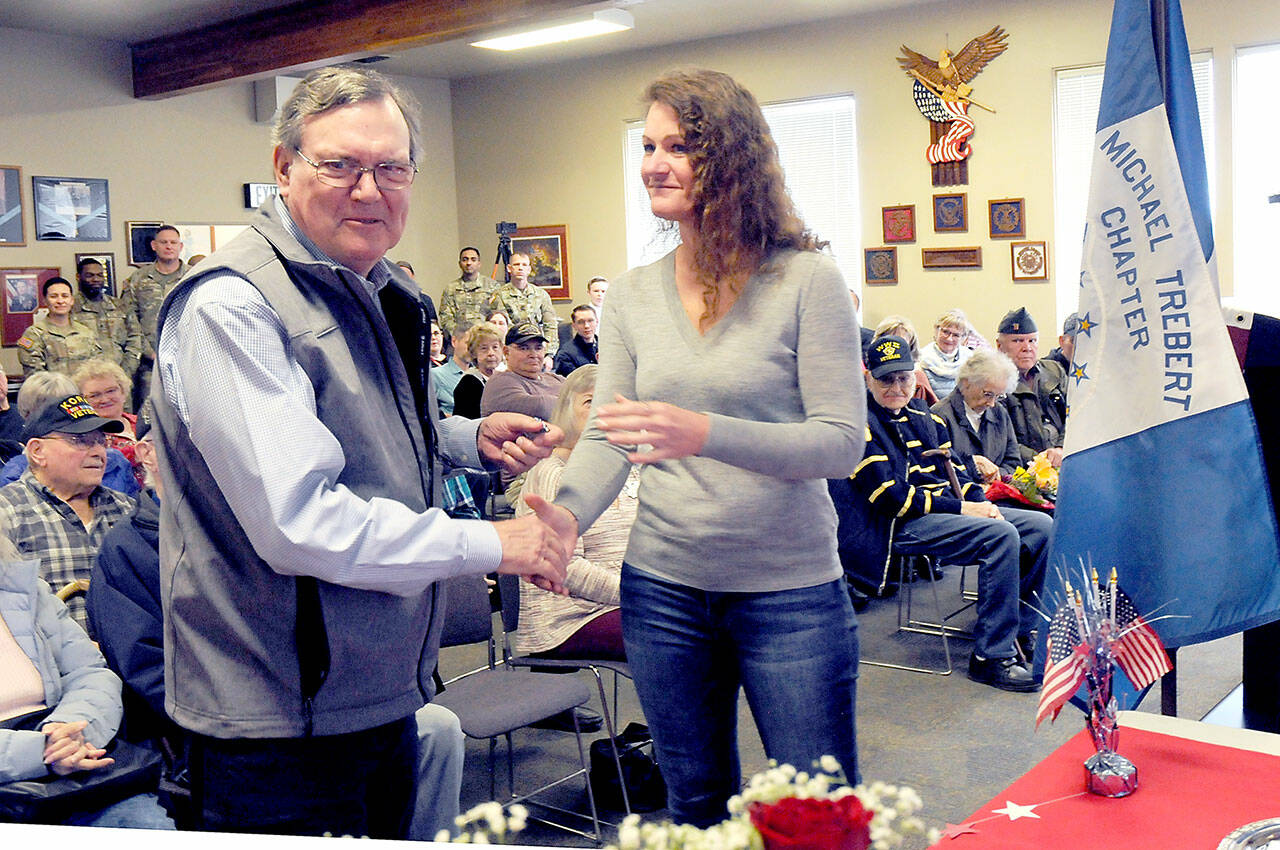 U.S. Air Force veteran Robert Reinking, left, receives a lapel pin from Holly Rowan, president of the Clallam County Veterans Association, during a Vietnam Veteran Commemorative Ceremony on Wednesday at the Northwest Veterans Resource Center in Port Angeles. (KEITH THORPE/PENINSULA DAILY NEWS)