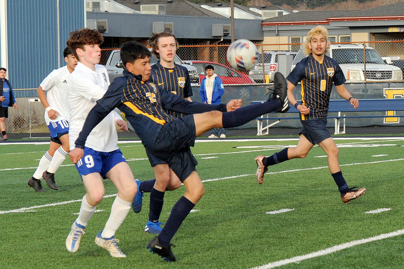 Spartan Jorge Diaz kicks back over his head towards the Forks goal while teammates Brody Owen and DeAnthony  Davila (8) look on.  Also in the action are Elma's Matthew Wood (9) and Theo Flores (10).  Photo by Lonnie Archibald.
