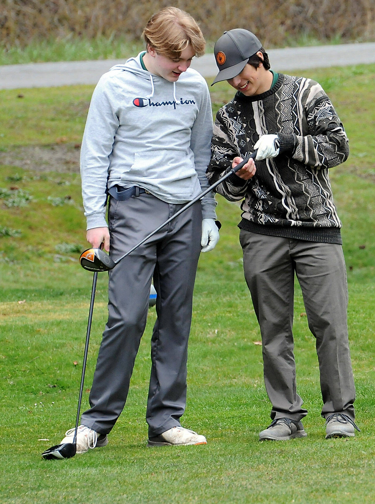 KEITH THORPE/PENINSULA DAILY NEWS Port Angeles golfers Nate Anderson, left, and Phoenix Flores examine Flores’ club on the first hole of Thursday’s match against Sequim at Peninsula Golf Club.