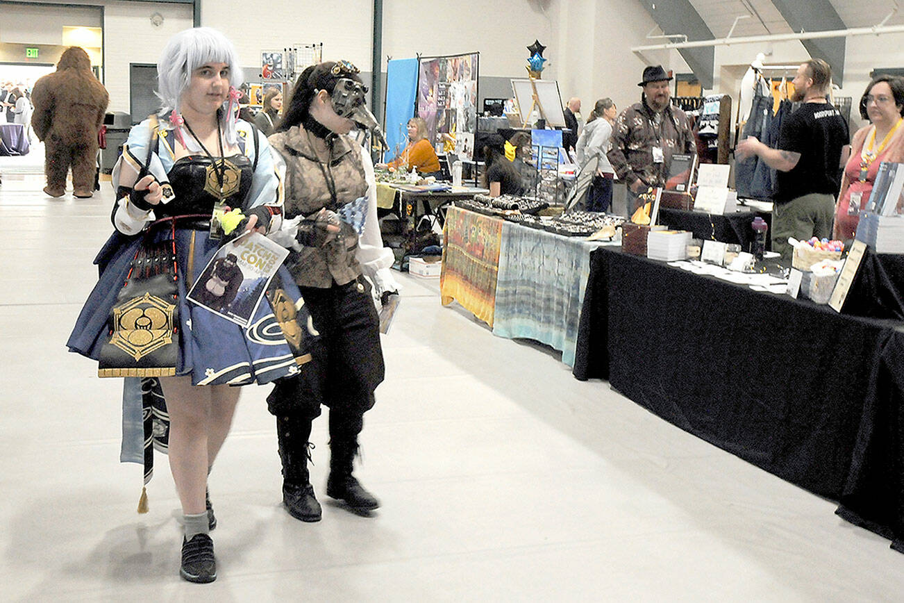 Sisters Ashlynn and Kellan Northaven of Port Angeles roam the artists market at the 2023 Squatchcon comic and arts convention on Saturday at Vern Burton Community Center in Port Angeles. The four-day event served as a celebration of gaming and culture and included panel discussions and workshops, as well as a cosplay contest. (Keith Thorpe/Peninsula Daily News)