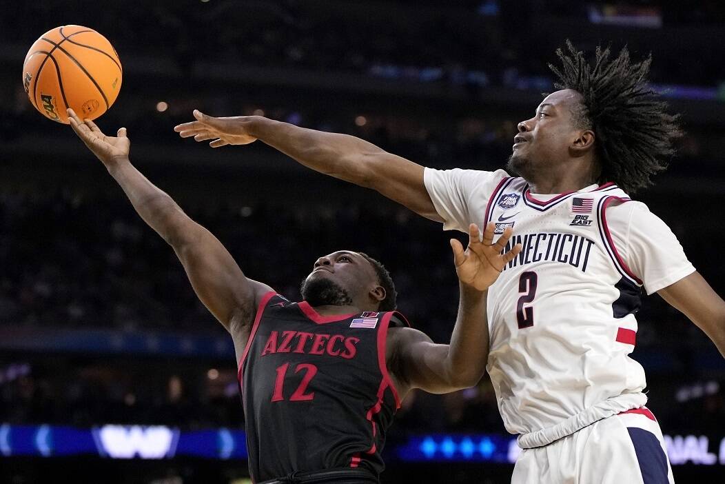 Connecticut guard Tristen Newton (2) blocks a shot by San Diego State guard Darrion Trammell during the second half of the men's national championship college basketball game in the NCAA Tournament on Monday, April 3, 2023, in Houston. (AP Photo/David J. Phillip)