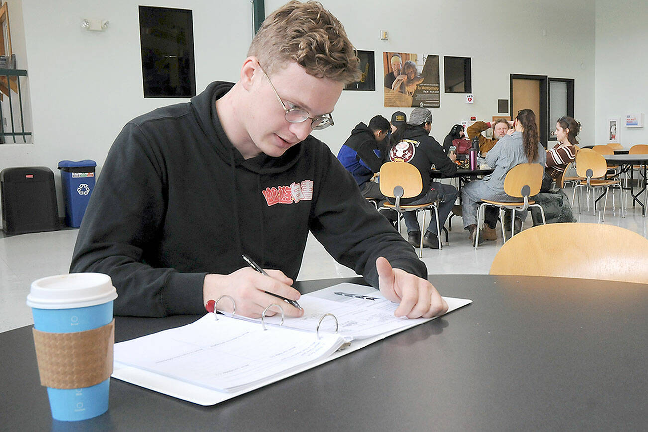 Bradley Taylor of Sequim takes time for classwork in the High School+ program on Tuesday in the Pirate Union Building on the Port Angeles campus of Peninsula College. Tuesday marked the beginning of the school’s spring academic quarter, which runs through June 16. (Keith Thorpe/Peninsula Daily News)