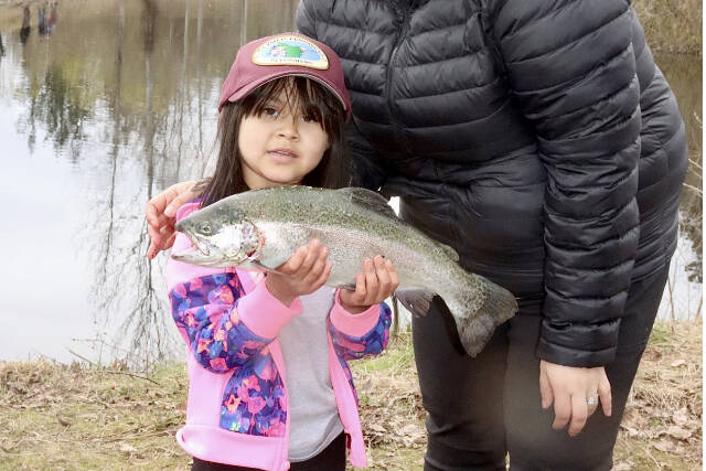 Jhene Laugayan, 5, of Port Angeles, caught the biggest fish of the Kid’s Fishing Derby on Saturday. Her rainbow trout was measured at 19 1/2 inches. She won a fishing pole, a tackle box and a hat from sponsor Olympic Peninsula Flyfishers. Her mom Jessica Laugayan helped with landing Jhene's fish. (Dave Logan/for Peninsula Daily News)