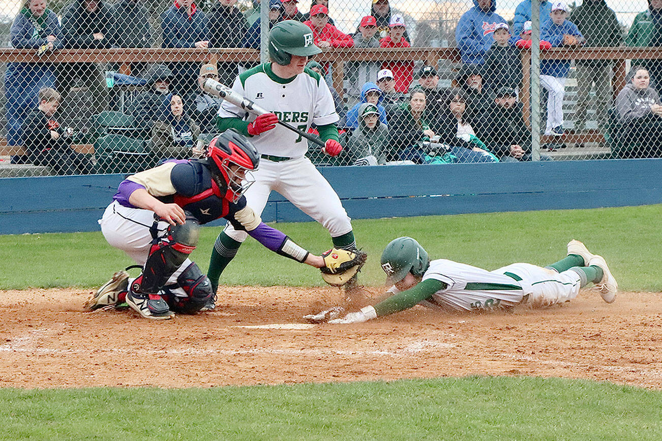 Port Angeles' Alex Angevine scores on a steal of home base in the first inning against Sequim at Civic Field on Tuesday, getting in just under the tag of Wolves' catcher Lincoln Bear. The batter is Port Angeles' Elijah Flodstrom. (Dave Logan/for Peninsula Daily News)