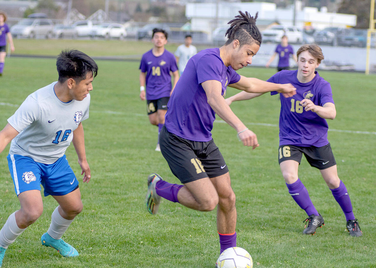 Emily Matthiessen/Olympic Peninsula News Group 
Sequim’s Mekhi Ashby possesses the ball while teammate James Mason, right, looks on during the Wolves’ 2-1 win over North Mason on Thursday.