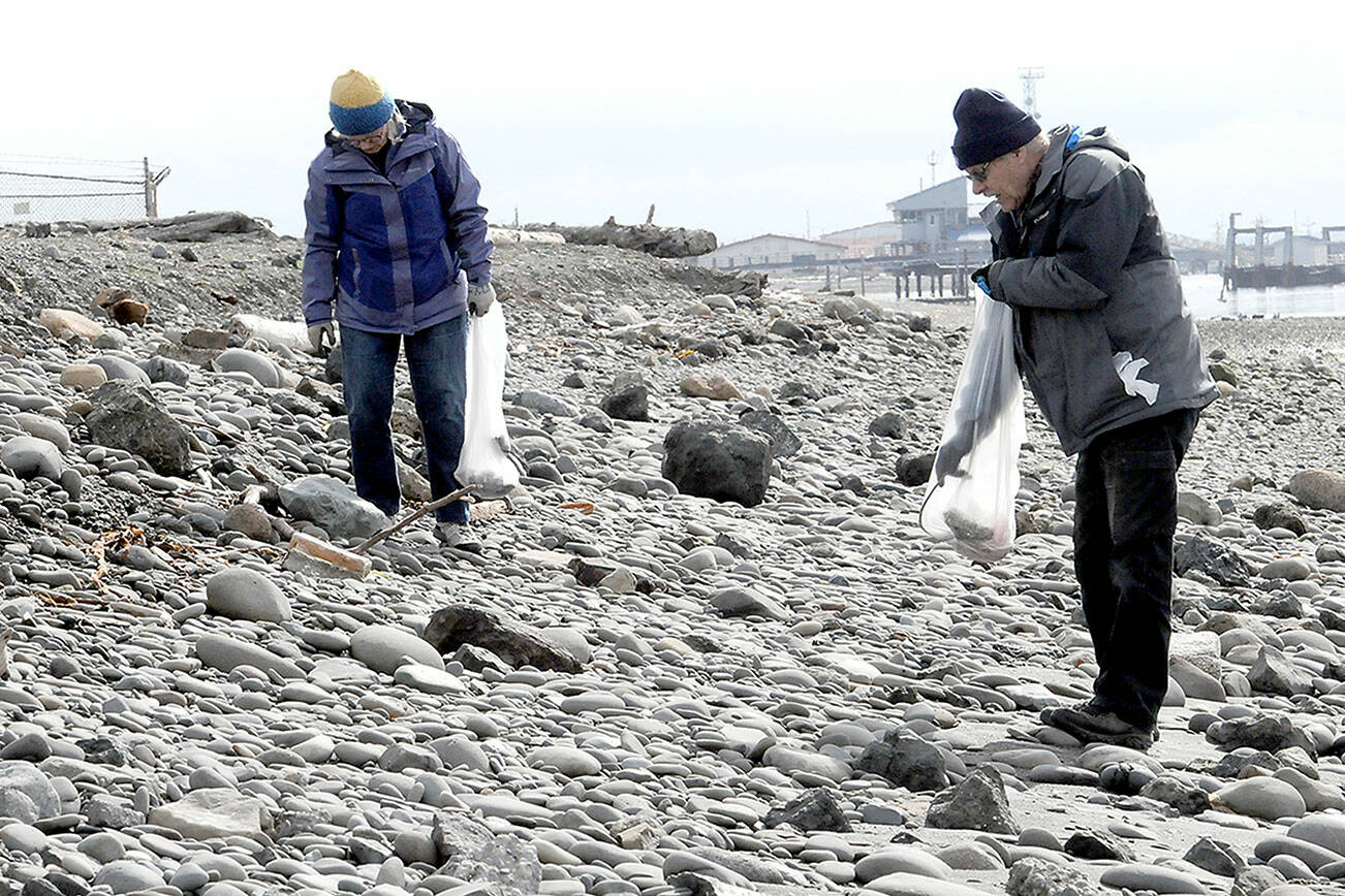 Joan Mickelson of Anacortes, left, and Doug Atterbury of Port Angeles scour the shores of Port Angeles Harbor on Ediz Hook on Saturday looking for refuse as an Earth Day activity in Port Angeles. Washington CoastSavers and Olympic National Park, as well as several other organizations, hosted beach cleanups across the North Olympic Peninsula. (Keith Thorpe/Peninsula Daily News)