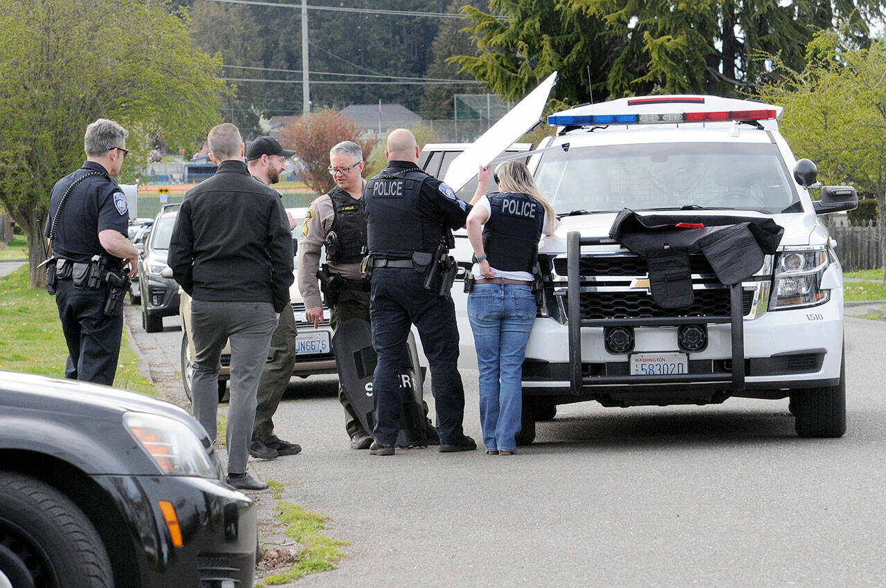 Port Angeles police and Clallam County Sheriff’s deputies gather at the scene of a standoff that forced closure of the 1100 block of East Third Street on Wednesday afternoon. (Keith Thorpe/Peninsula Daily News)
