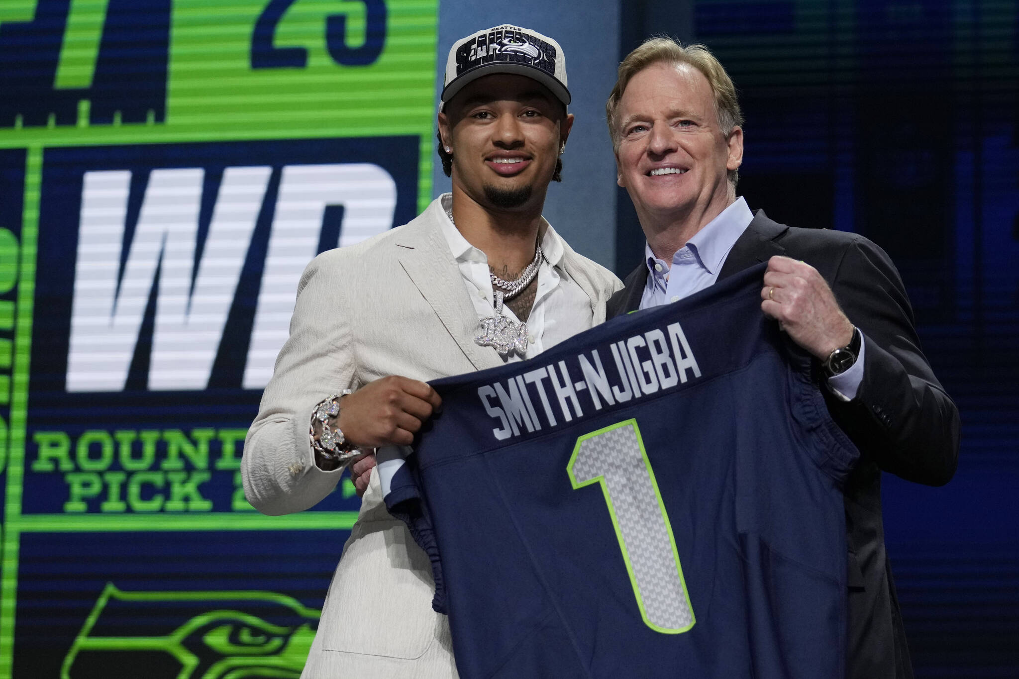 Ohio State wide receiver Jaxon Smith-Njigba, left, poses with NFL Commissioner Roger Goodell after being chosen by the Seattle Seahawks with the 20th overall pick during the first round of the NFL football draft, Thursday, April 27, 2023, in Kansas City, Mo. (AP Photo/Jeff Roberson)