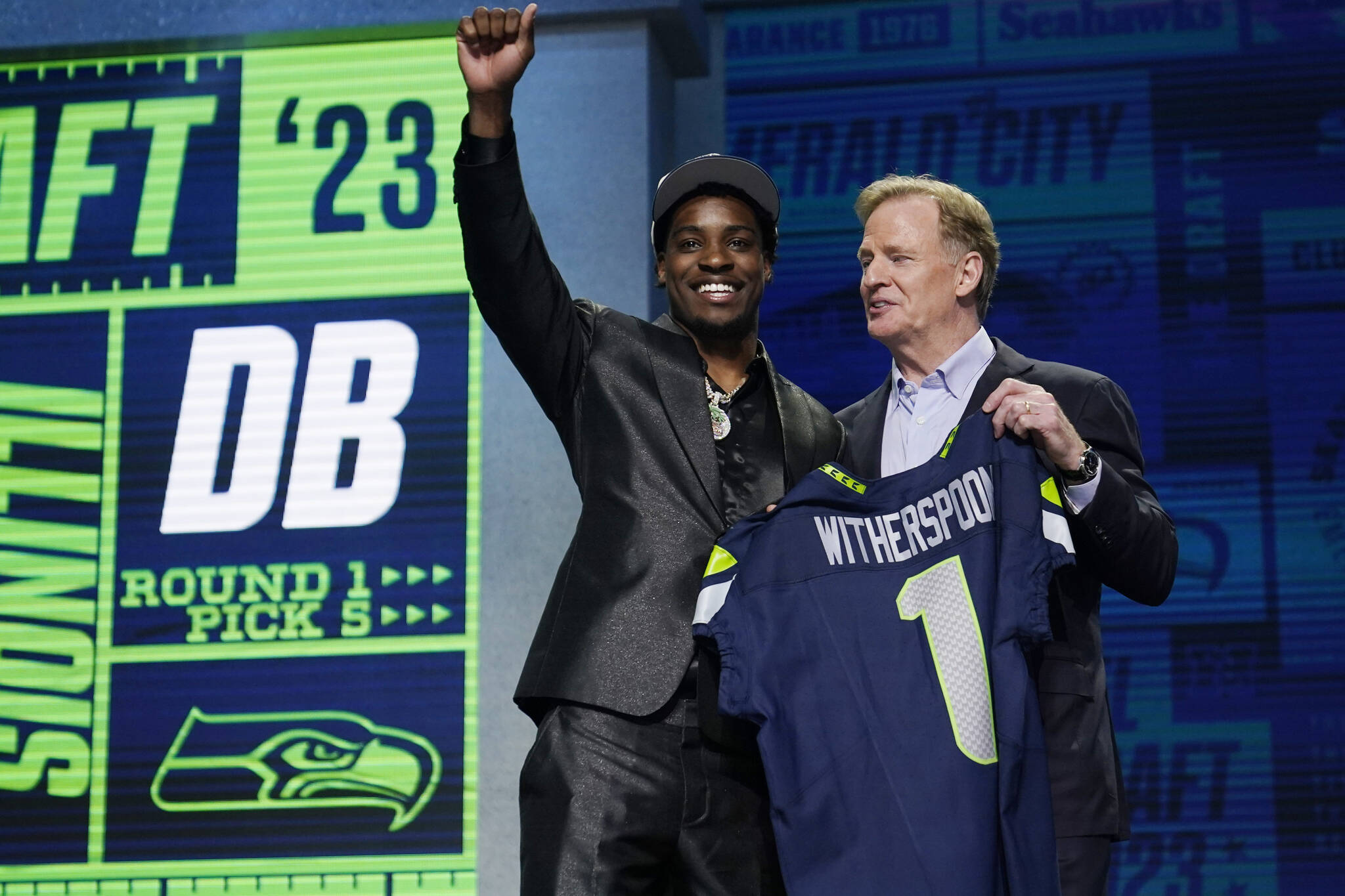 Illinois defensive back Devon Witherspoon, left, stands with NFL Commissioner Roger Goodell after being chosen by the Seattle Seahawks with the fifth overall pick during the first round of the NFL football draft, Thursday, April 27, 2023, in Kansas City, Mo. (AP Photo/Jeff Roberson)