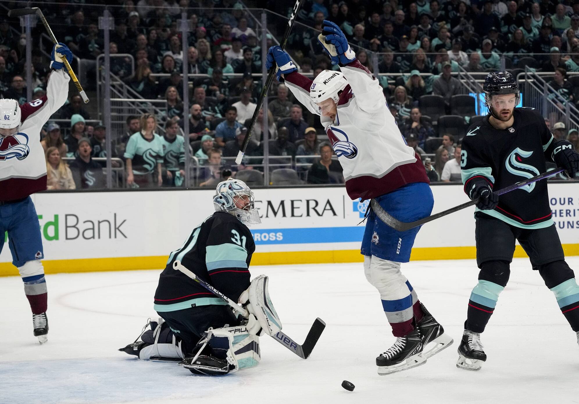 Colorado Avalanche center Nathan MacKinnon (29) and left wing Artturi Lehkonen, left, celebrate a goal by defenseman Erik Johnson, as Seattle Kraken goaltender Philipp Grubauer (31) and defenseman Will Borgen (3) react during the second period of Game 6 of an NHL hockey Stanley Cup first-round playoff series Friday, April 28, 2023, in Seattle. (AP Photo/Lindsey Wasson)