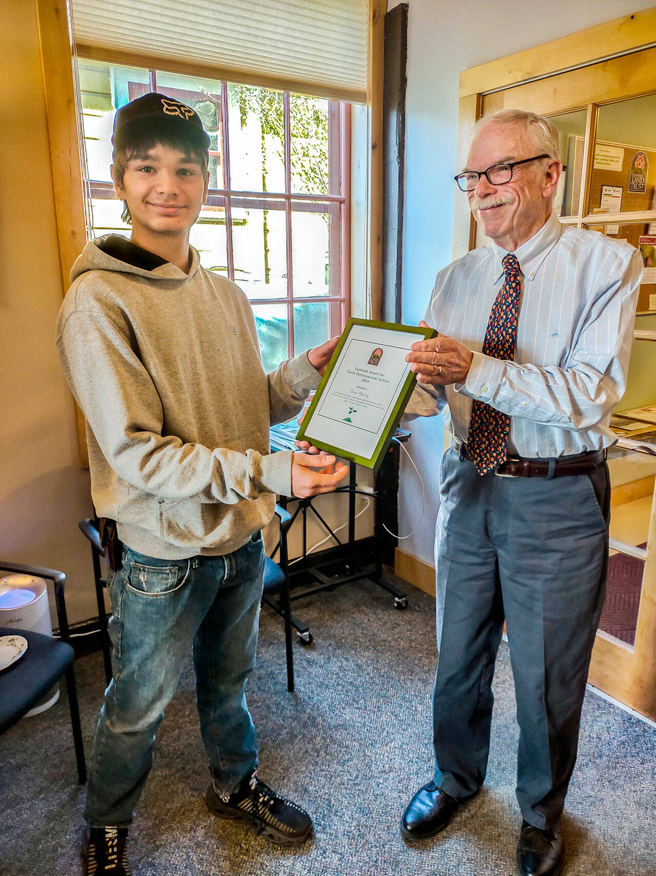 Diego Murray, left, accepts the Fairbank Award for Youth Environmental Action from Richard Tucker, executive director of the Jefferson Land Trust. (photo by Lilly Schneider)