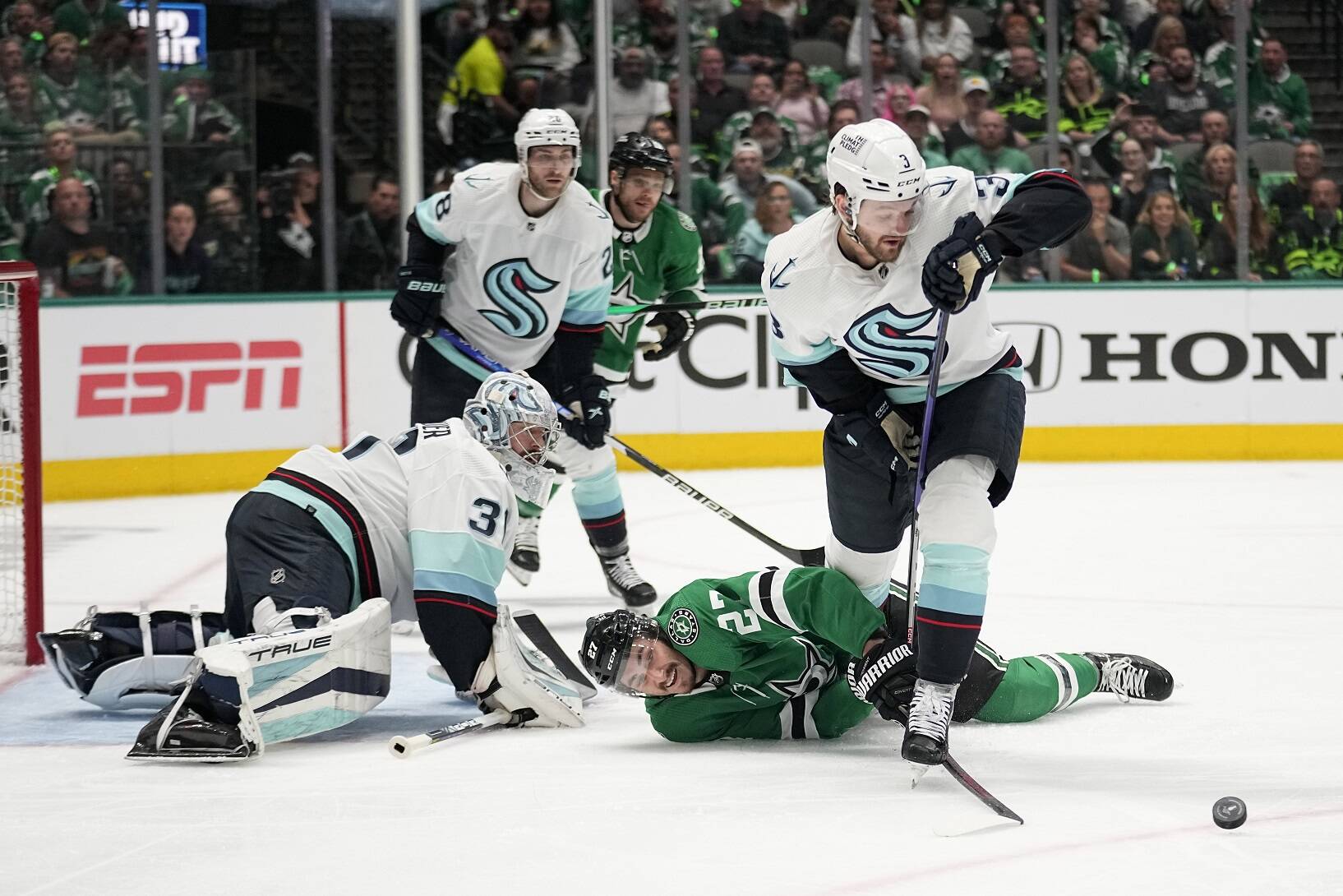 Dallas Stars left wing Mason Marchment, center, attempt to reach the puck in front of Seattle Kraken’s Philipp Grubauer as defenseman Will Borgen, right, moves to take control in the first period of Game 1 of an NHL hockey Stanley Cup second-round playoff series, Tuesday, May 2, 2023, in Dallas. (AP Photo/Tony Gutierrez)