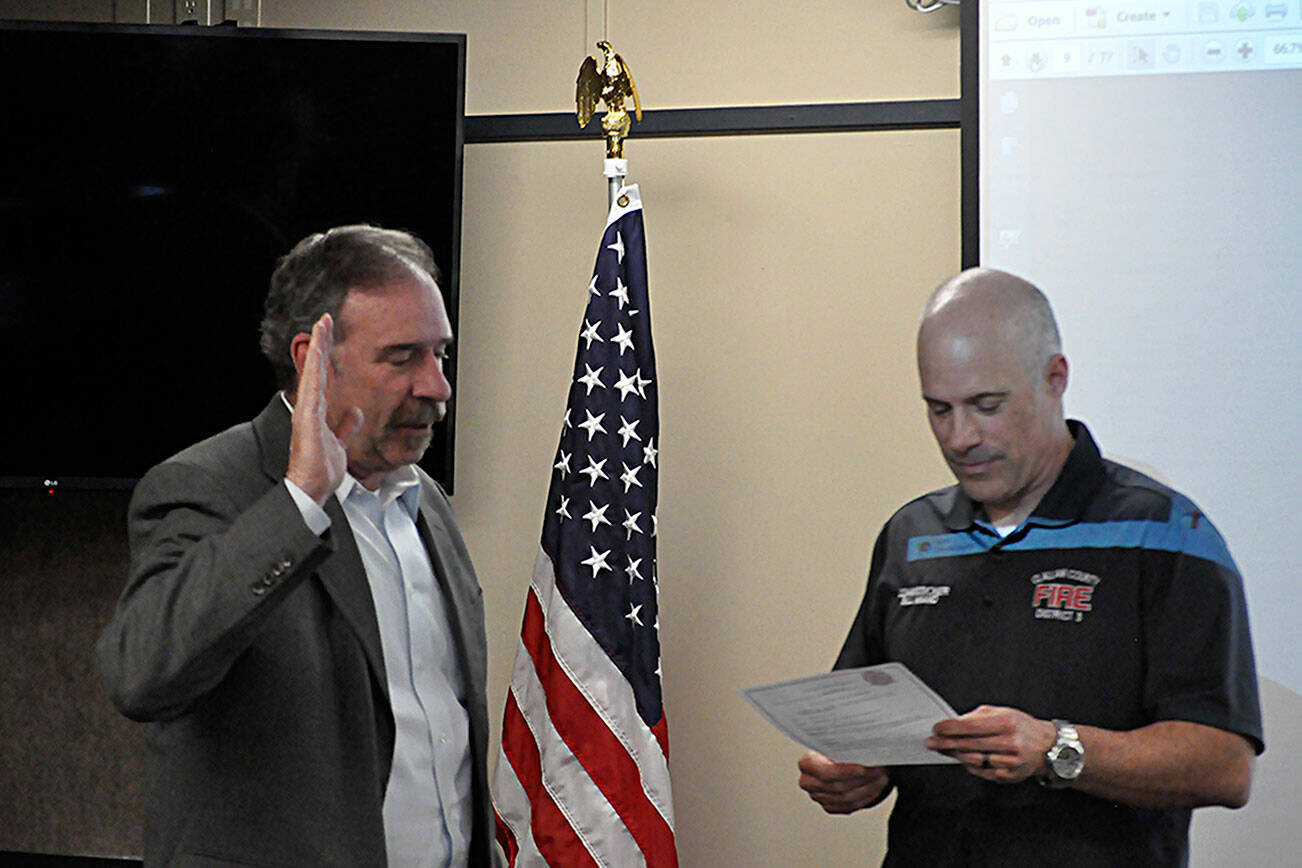 Fire commissioner Bill Miano, right, swears in appointed commissioner Mike Mingee on May 2 during a meeting of the Clallam County Fire District 3’s board of commissioners. Mingee told commissioners in April he’s planning to file to run for the position this month. (Matthew Nash/Olympic Peninsula News Group)