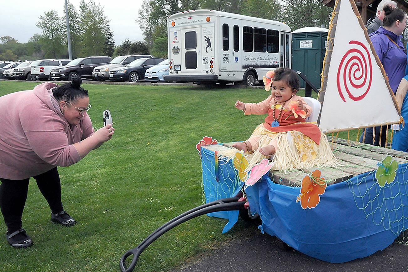 Lesley Welch of Sequim takes a photo of her daughter, Avani Welch, 1, on a Moana-themed mini float during Saturday’s Irrigation Festival Kids Parade at the Haller Athletic Fields in Sequim. The float was awarded grand prize by the judges, taking top honors in the parade. (Keith Thorpe/Peninsula Daily News)