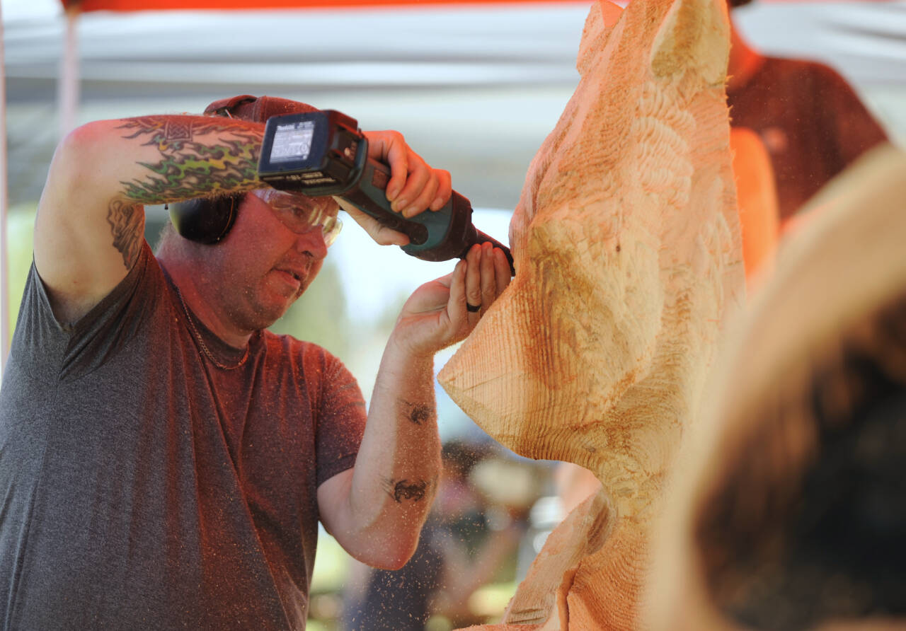Nick Bielby of the Port Angeles-based Nicklby Wood Carving, works on a large bear sculpture at the Sequim Irrigation Festival Logging Show on Friday. (Michael Dashiell/Olympic Peninsula News Group )