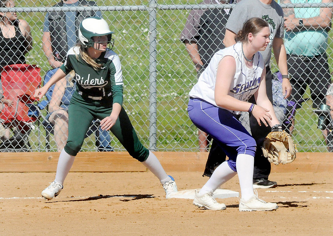Port Angeles’ Natalie Robinson, left, watches the pitch as Sequim first baseman Sammie Bacon keeps tabs on Friday in Port Angeles. (Keith Thorpe/Peninsula Daily News)
