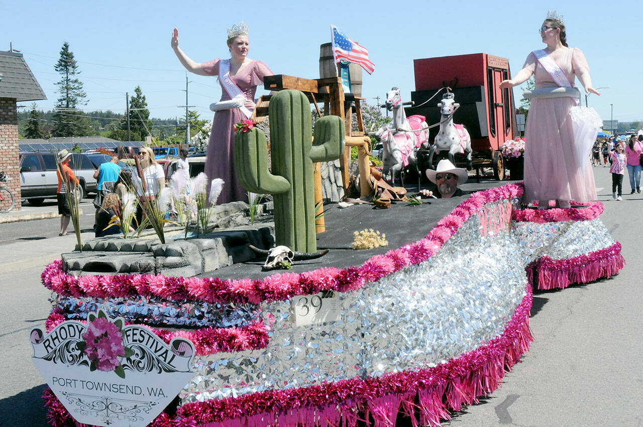 Port Townsend Rhody Festival royalty, Queen Melody Douglas, left, and Princess Paige Govia wave to the Irrigation Festival Grand Parade crowds from their float, driven by Bliss Morris, on Saturday. (Keith Thorpe/Peninsula Daily News)