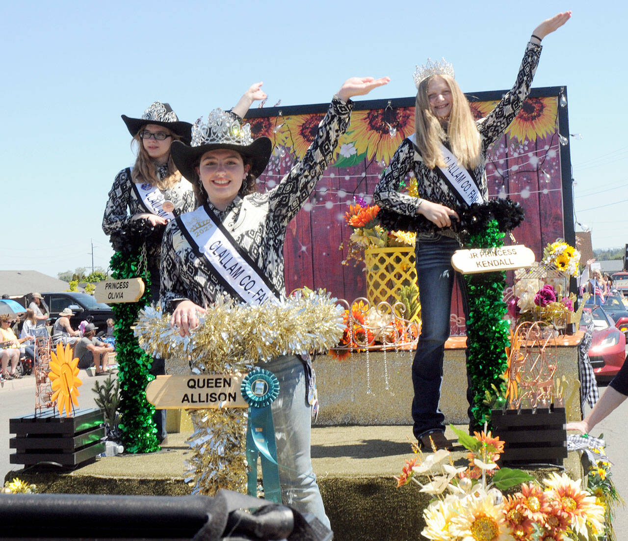 Clallam County Fair royalty, from left, Princess Olivia Ostlund, Queen Allison Pettit and Junior Princess Kendall Adolphe ride their festival float, which received the Irrigation Festival Chairmans Award. (Keith Thorpe/Peninsula Daily News)