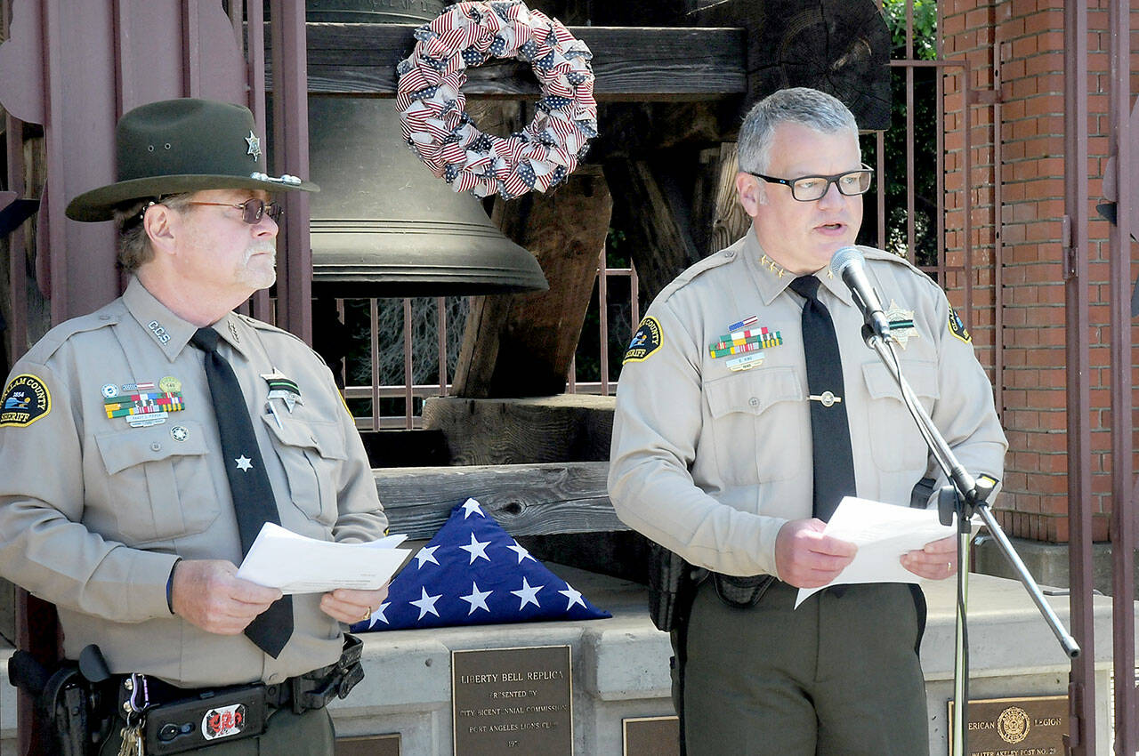 Clallam County Sheriff Brian King, right, speaks about the service of law enforcement personnel as Sgt. (Ret.) Randy Pieper listens in during Friday’s bell-ringing ceremony on National Peace Officer Memorial Day at Veteran’s Park in Port Angeles. (KEITH THORPE/PENINSULA DAILY NEWS)