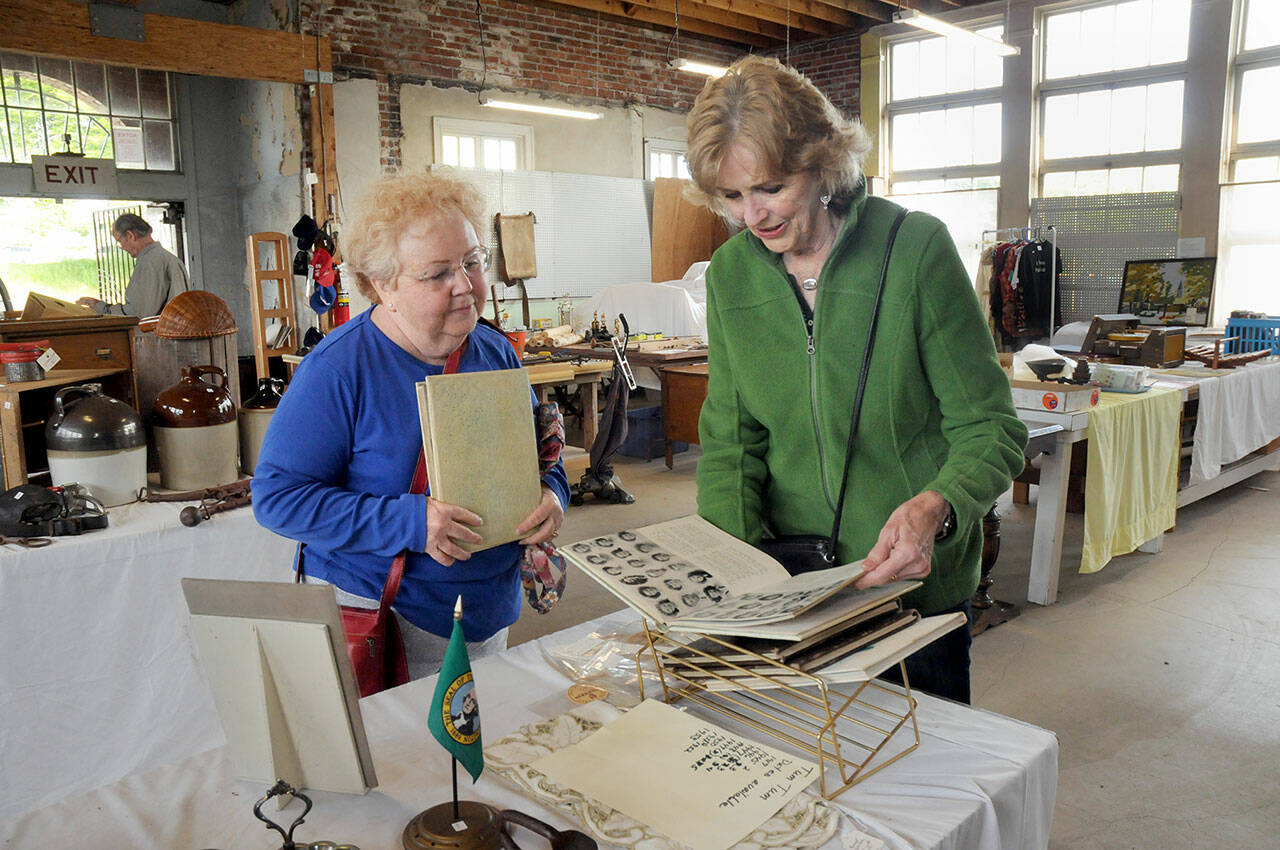 Maureen Sandison, left, and Valle Nevaril, both of Port Angeles, examine high school year books on sale at the North Olympic History Center’s Vintage Sale on Saturday at the former Lincoln School in Port Angeles. The sale, which included collectables, vintage clothing, tools and other items, was designed to benefit the center’s programs and operations. (Keith Thorpe/Peninsula Daily News)