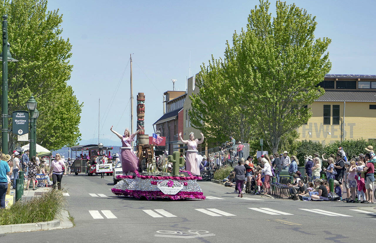 Rhody Queen Melody Douglas, left, and Princess Paige Govia wave and dance while rolling along Water Street in downtown Port Townsend during the 94th annual Rhody Parade on Saturday. (Steve Mullensky/for Peninsula Daily News)