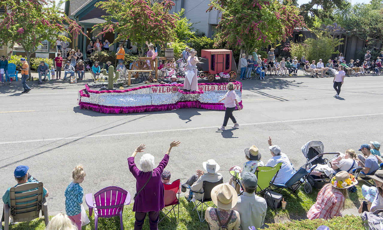 Rhody Queen Melody Douglas, left, and Princess Paige Govia, wave to the spectators lining both sides of Lawrence Street in Uptown Port Townsend during the 94th annual Rhody Festival and Parade on Saturday. There were 94 entrants in this year’s parade, which boasted warm weather and sunny skies. (Steve Mullensky/for Peninsula Daily News)