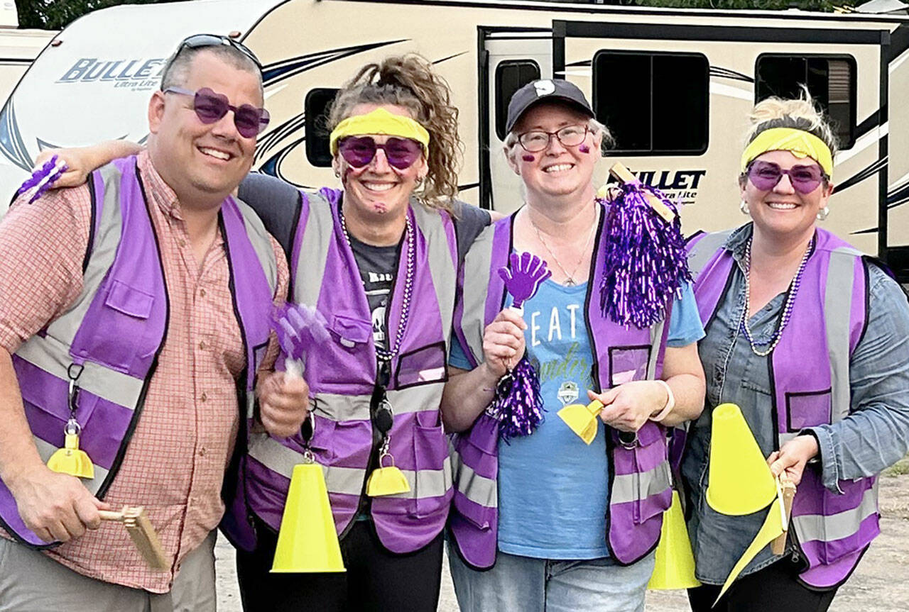 Sequim parents cheered the team on wearing their fan vests made by mom Anna Swanberg. Bryan Swanberg, left, Anna, Christie Sharpe and Misty Gilbertson.