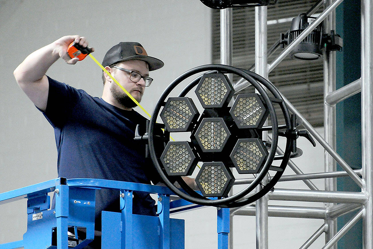 KEITH THORPE/PENINSULA DAILY NEWS
Levi Plumb of Seattle-based R90 Lighting adjusts a stage light on the Main Stage on Thursday in Vern Burton Community Center for this weekend's Juan de Fuca Festival of the Arts.