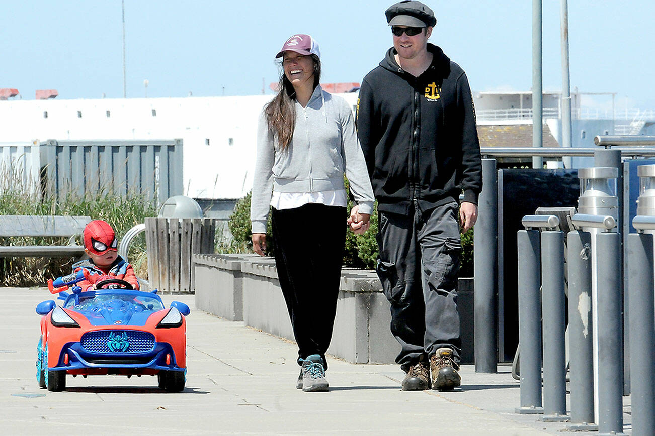 Goby McCaffrey, 3, does his best Spiderman act in his battery-powered Spider-Mobile with his parents, Teresa and Travis McCaffrey of Port Angeles, while strolling the Esplanade on the Port Angeles waterfront on Wednesday. The family was on a springtime stroll and the youngster had insisted on superhero regalia. (Keith Thorpe/Peninsula Daily News)