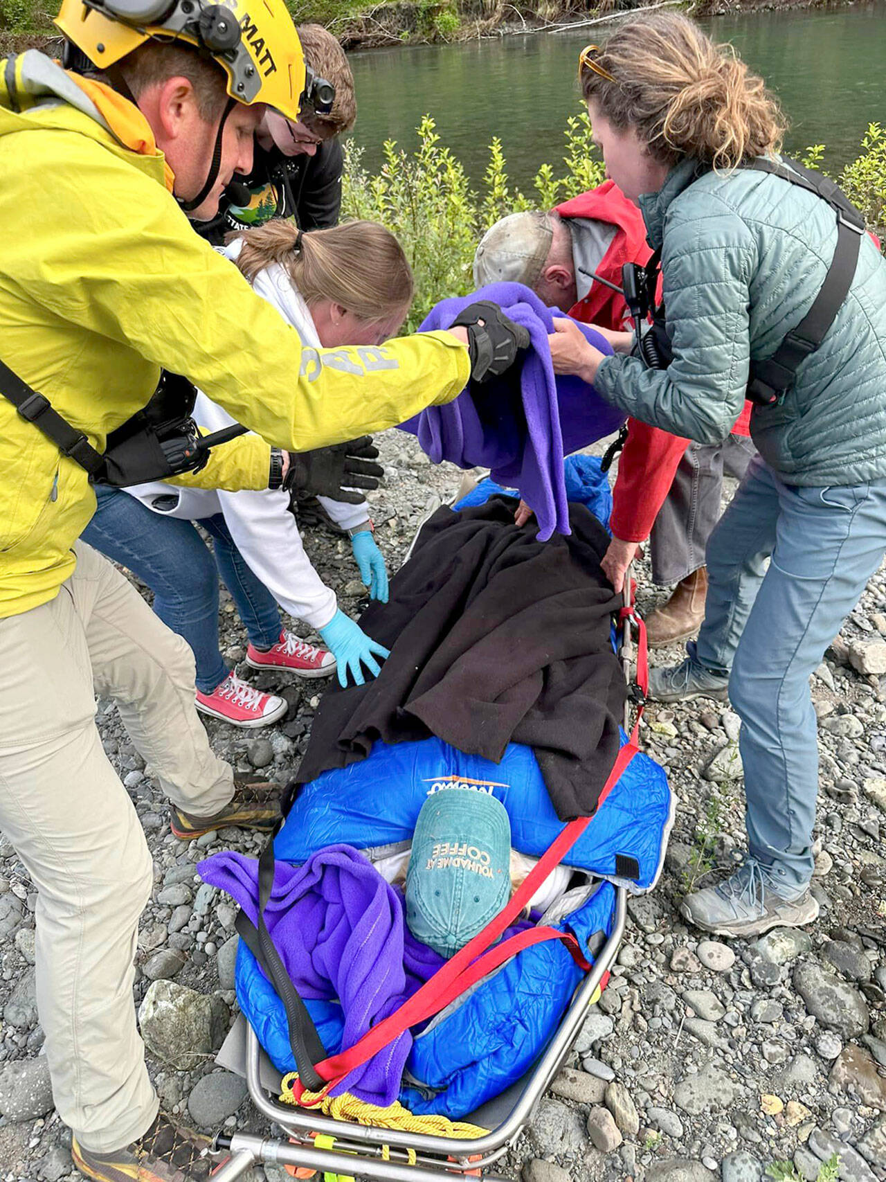 Rescuers in Jefferson County assist a woman on Wednesday who went looking for a hiker reported missing on Monday. The woman was injured attempting to cross the Duckabush River and transported to Jefferson Healthcare hospital in Port Townsend. (Brinnon Fire Department)