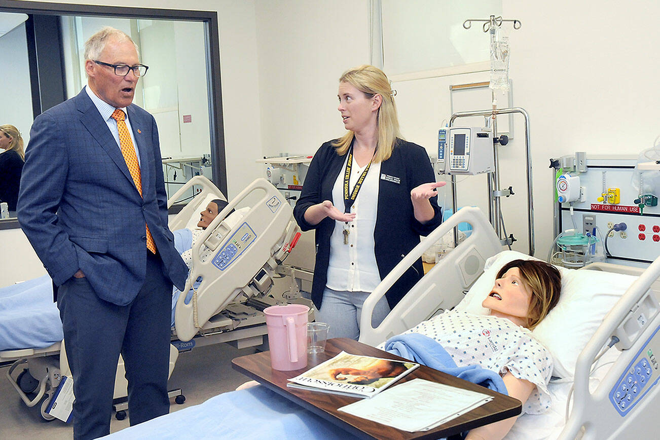 KEITH THORPE/PENINSULA DAILY NEWS
Gov. Jay Inslee  looks at a patient simulator as Peninsula College nursing instructional technician Terresa Taylor describes its workings during a tour of the college's Nursing Simulation Lab on Friday in Port Angeles.