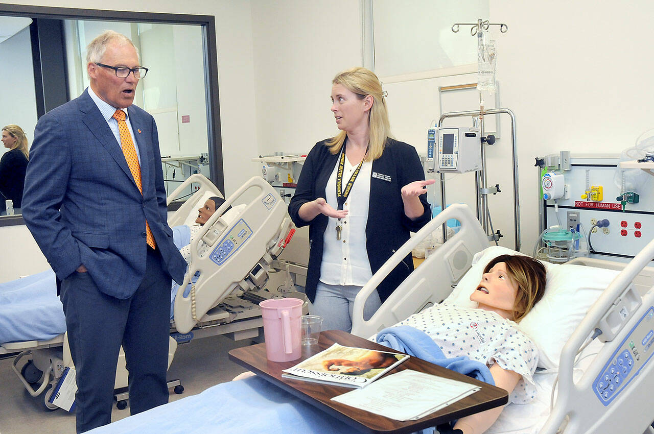Gov. Jay Inslee looks at a patient simulator as Peninsula College nursing instructional technician Terresa Taylor describes its workings during a tour of the college’s Nursing Simulation Lab on Friday in Port Angeles. (KEITH THORPE/PENINSULA DAILY NEWS)