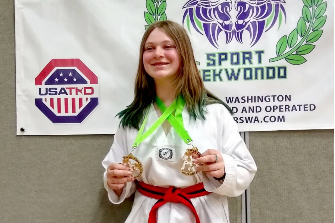 Camryn Waggoner shows off the two gold medals she won at the Twin Tigers taekwondo tournament in Tacoma this weekend. She is a student at White Crane Martial Arts in Port Angeles. (Courtesy photo)