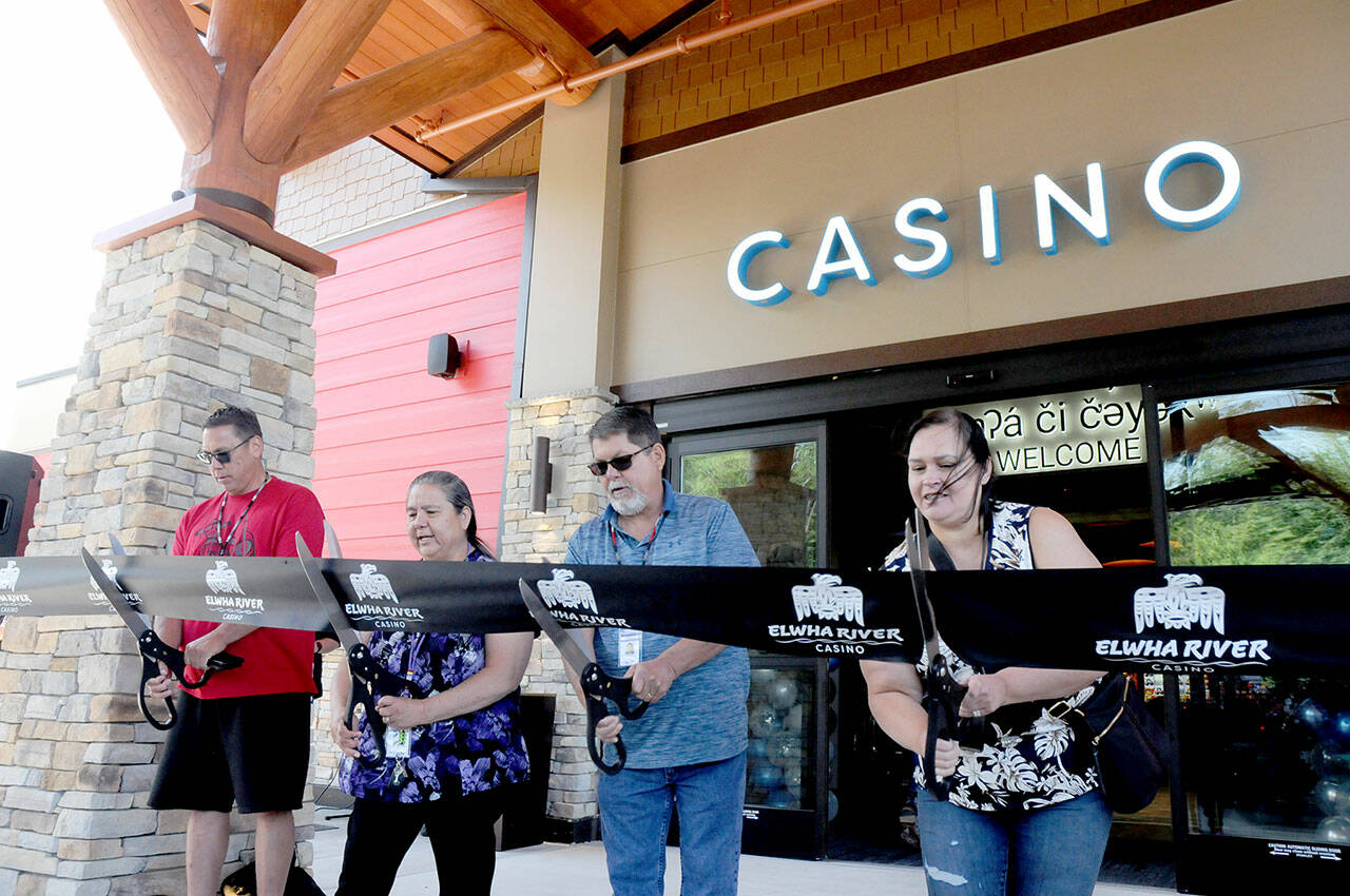 Lower Elwha Klallam tribal leaders, from left, Council member Steve Robideau, tribal chairwoman Frances Charles, and council members Anthony Charles and Melissa Gilman weild scissors to cut the ribbon, officially opening the expanded Elwha River Casino on Thursday. (KEITH THORPE/PENINSULA DAILY NEWS)
