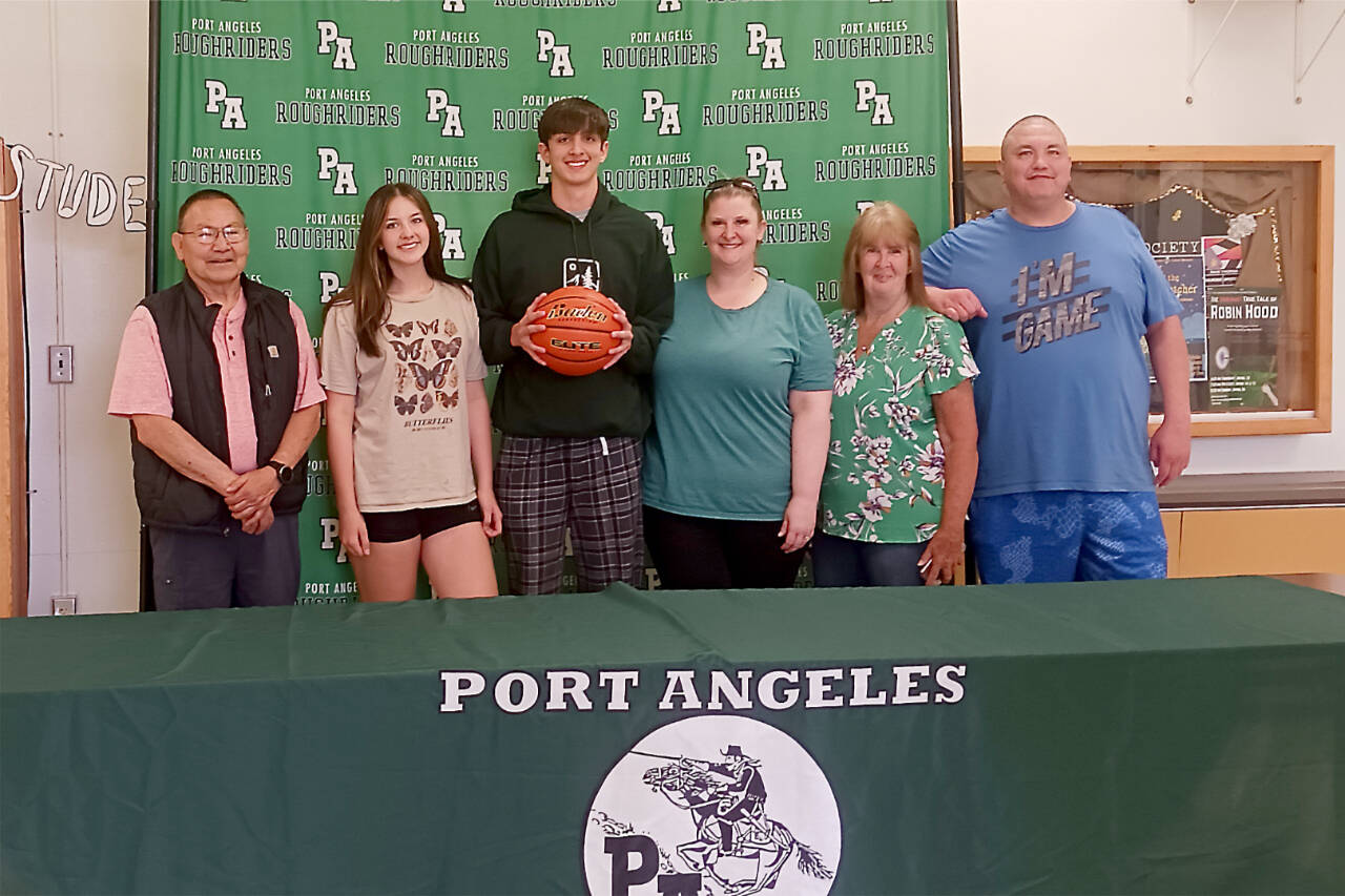 From left, grandfather Robert Elofson, sister Shyanne Austin, Tyler Hunter, mother Tammy Hunger, grandmother Barbara Sellers and dad Jason Hunter all celebrate Tyler signing to play basketball for The Evergreen State University. (Pierre LaBossiere/Peninsula Daily News)