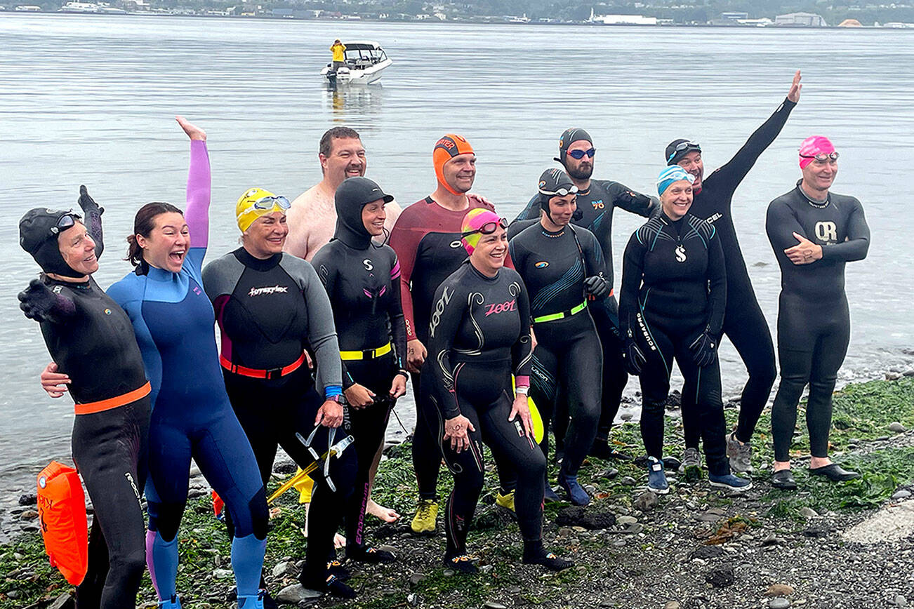 Participants in the Maritime Festival’s Orca Bait Swim pump themselves up on Ediz Hook before heading out across the harbor. The inaugural event drew 12 swimmers and three orcas, whose paths did not happen to meet over the 1 1/2-mile course. (Paula Hunt/Peninsula Daily News)
