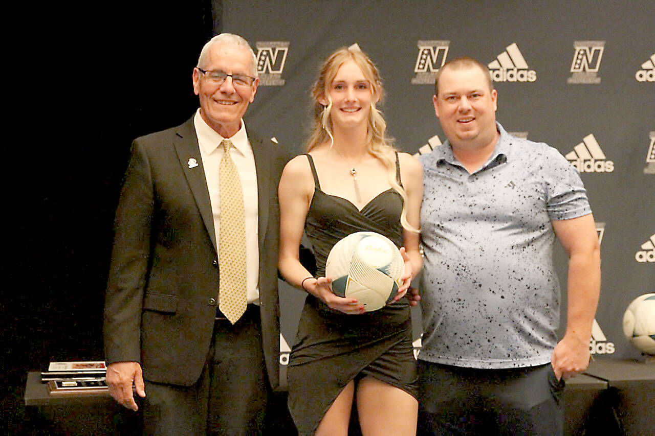 From left, Peninsula College Associate Dean for Athletics and Student Life Rick Ross, Peninsula College soccer and basketball player Millie Long and Baden NW Regional Manager Brandon Williams at the NWAC awards banquet in Pasco on Tuesday. (Duncan Stevenson photo)