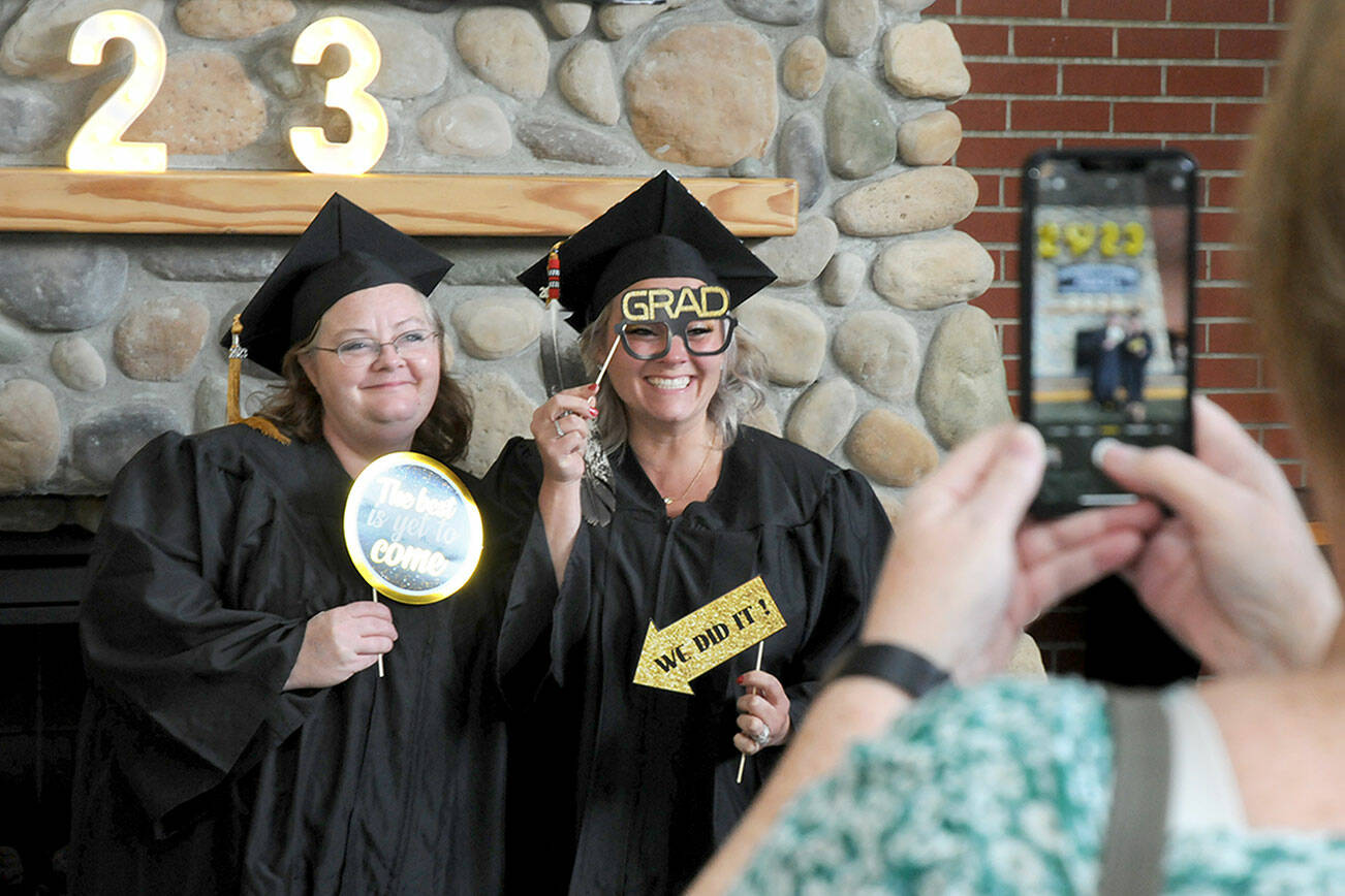 Peninsula College graduates April Fordyce-Blewett, left, and Deborah Ceja-Cisneros, both of Forks, have a photograph taken by Fordyce-Blewett’s mother, Peggy Blewett, prior to the first of two commencement ceremonies on Saturday on the college’s Port Angeles campus. A total of 388 degrees and certificates were awarded for the 2022-23 school year with 270 people signed up to participate Saturday’s ceremonies. (Keith Thorpe/Peninsula Daily News)