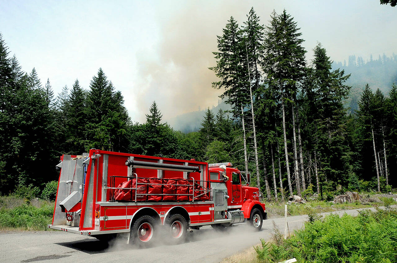 An engine truck from Clallam County Fire District 2 parks at the end of Joyce Access Road in Indian Valley southwest of Port Angeles as a wildland fire burns farther uphill on Saturday. (Keith Thorpe/Peninsula Daily News)