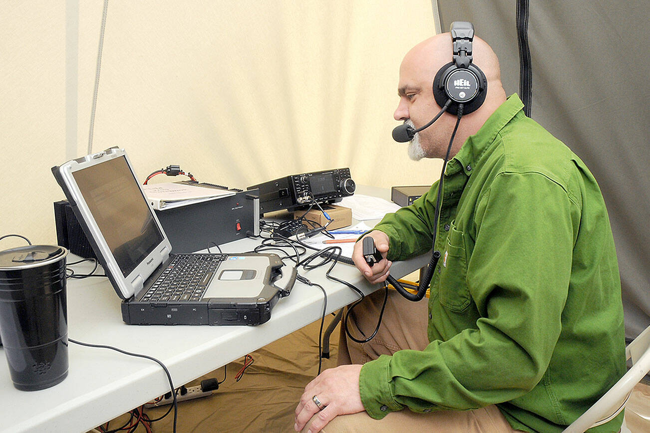 KEITH THORPE/PENINSULA DAILY NEWS
Radio operator Chris Icide of Joyce, who uses the call sign WY7W, talks to other radio stations while broadcasting from a tent on Saturday at the Clallam County Fairgrounds in Port Angeles as part of Field Day, an international competition where partcipants attempt to log as many contacts across the United States and Canada as possible in a 24-hour period. The North Amerian event was coordinated nationally by the American Radio Relay League and hosted locally by the Clallam County Amateur Radio Club.